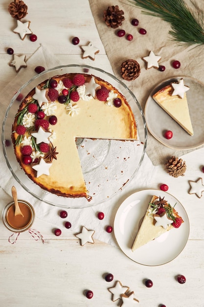 Köstlicher Weihnachtskäsekuchen mit Preiselbeeren und Kekssternen auf einem weißen Tisch