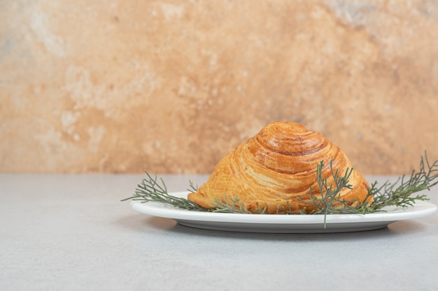 Köstliches Brötchen mit Fleisch und Karotte auf weißer Oberfläche