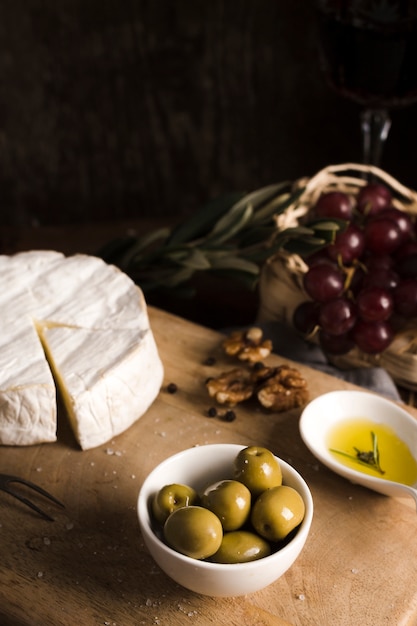 Köstliches Buffet des hohen Winkels mit Käse und Oliven auf hölzernem Brett