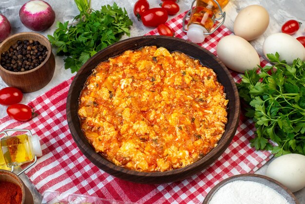 Köstliches Omelett mit halber Draufsicht mit gebratenen Tomaten um Grüns und Gemüse auf weißem Hintergrund Morgenfrühstück Brot Milch Mittagessen