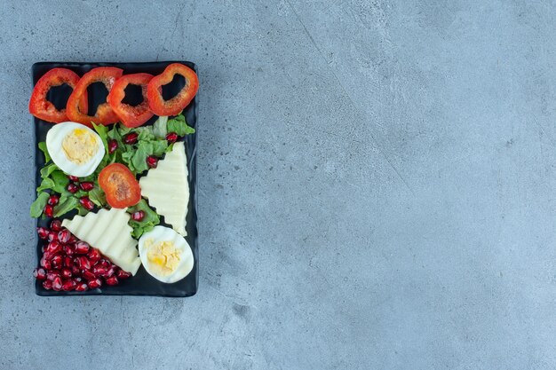 Köstliches, reichhaltiges Frühstück auf einer schwarzen Platte auf Marmor.