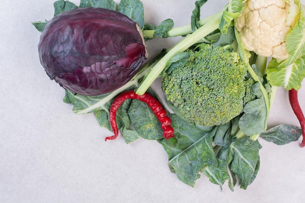 Kohl, Blumenkohl und Grüns auf weißem Tisch.