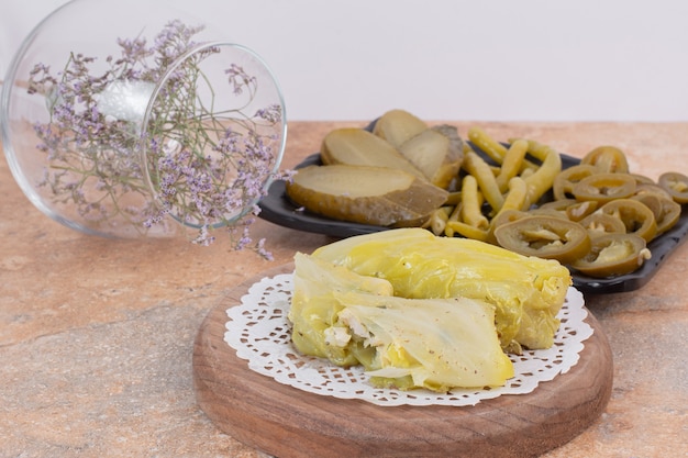 Kohl dolma brötchen und teller mit gurken auf orange oberfläche.