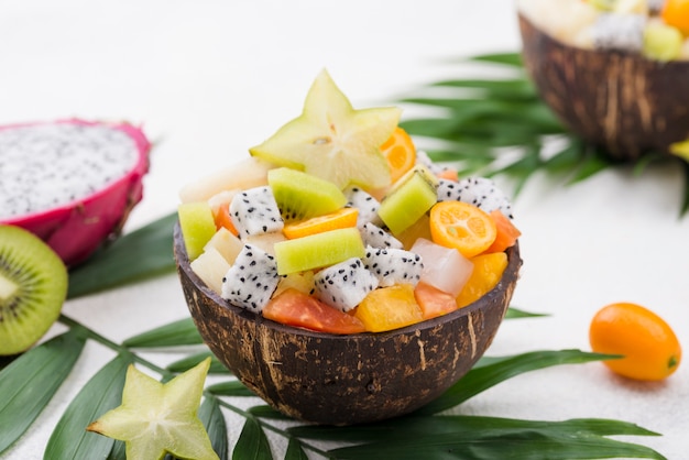 Kostenloses Foto kokosnuss gefüllt mit obstsalat hohe ansicht