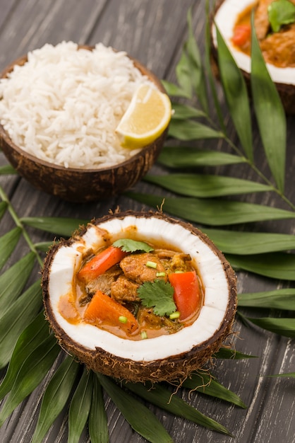 Kokosnusshälften gefüllt mit Eintopf und Reis