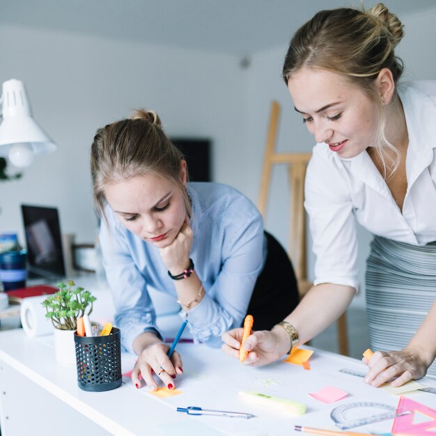 Kollege, der Projektdiagramm am Arbeitsplatz im Büro vorbereitet