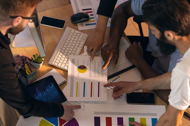 Kollegen arbeiten in einem modernen Büro mit Geräten und Gadgets während kreativer Besprechungen zusammen together