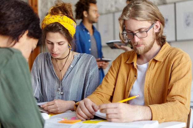 Kostenloses Foto kollegen arbeiten zusammen, während sie im café sitzen