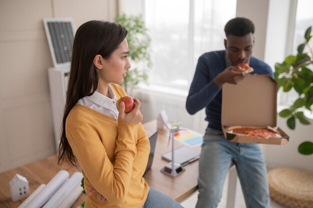 Kollegen bei der Arbeit essen Pizza