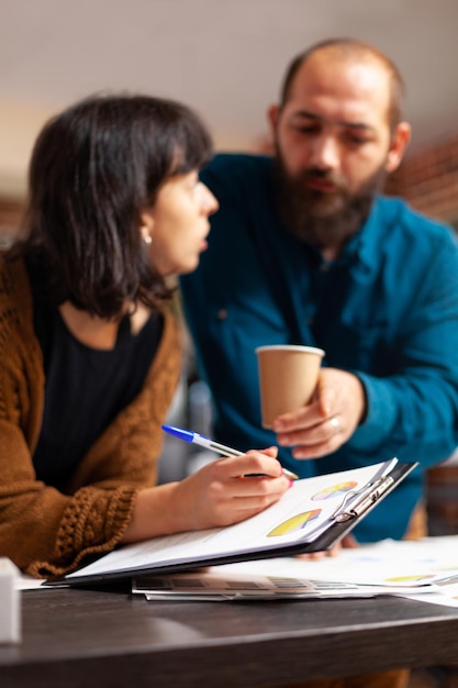 Kostenloses Foto kollegen diskutieren projektideen, analysieren die marketingstrategie und schreiben einen geschäftsbericht im startup-büro. geschäftsleute, die ein unternehmenstreffen planen, das an einer managementpräsentation arbeitet