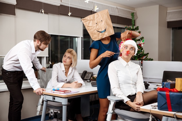 Kostenloses Foto kollegen feiern weihnachtsfeier im büro und trinken champagner lächelnd.