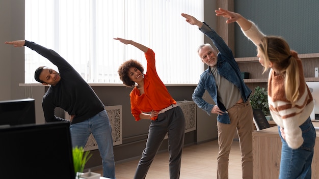 Kollegen im Büro dehnen sich während eines Arbeitstages