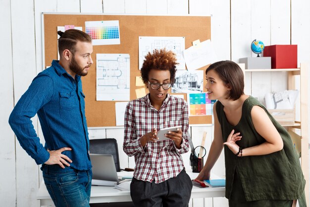 Kollegen lächeln, sprechen, diskutieren neue Ideen im Büro