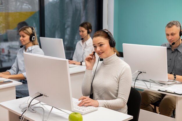 Kollegen mit Kopfhörern, die in einem Callcenter-Büro arbeiten