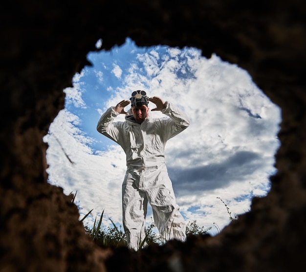 Ökologe gräbt Grube mit Schaufel und pflanzt Baum in verschmutztem Gebiet