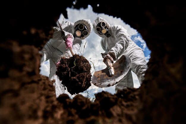 Ökologen graben Grube mit Schaufel und pflanzen Baum in verschmutztem Gebiet