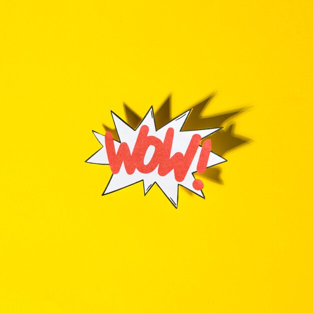 Komische Boomblase mit Ausdruckstext wow mit Schatten auf gelbem Hintergrund