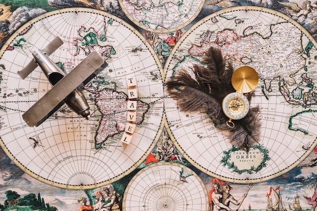 Kompass und Federn in der Nähe von Reisen schreiben und Flugzeug