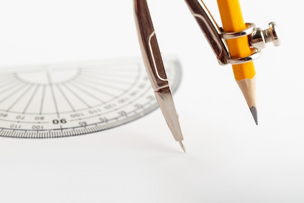 Kompass zum Zeichnen und Zeichnen isoliert mit Bleistift auf weißem Schreibtisch