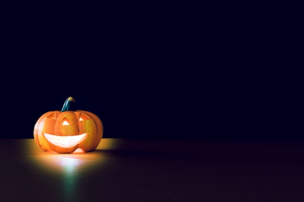 Komposition für Halloween mit beleuchtetem Kürbis