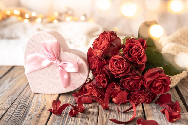 Kostenloses Foto komposition zum valentinstag mit einer geschenkbox und einem rosenstrauß