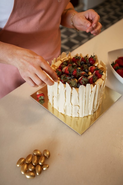 Kostenloses Foto konditorin mit einem erdbeerkuchen in der konditorei