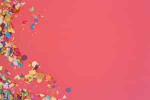 Kostenloses Foto konfetti über rosa hintergrund