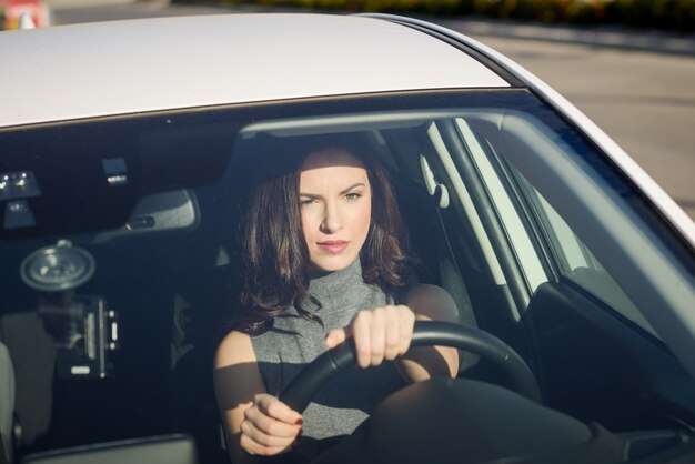 Konzentrierte Frau, die ihr Auto fahren