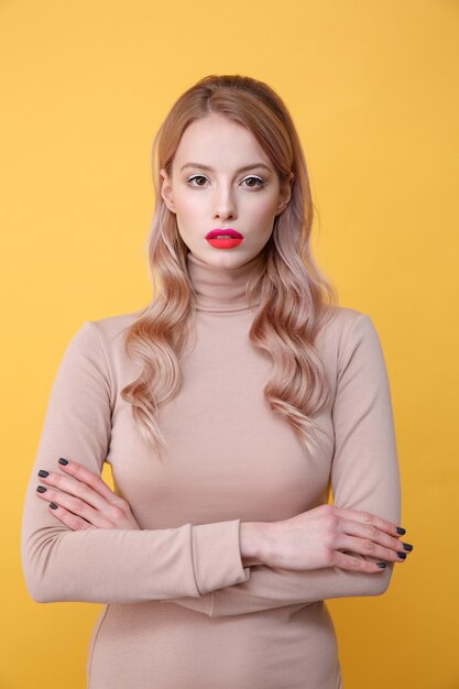 Konzentrierte junge blonde Dame mit hellen Make-up-Lippen