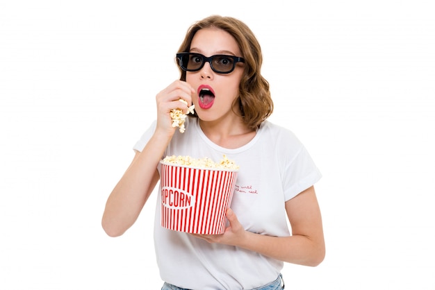 Konzentrierte kaukasische Frau, die Popcorn trägt 3d Brille hält