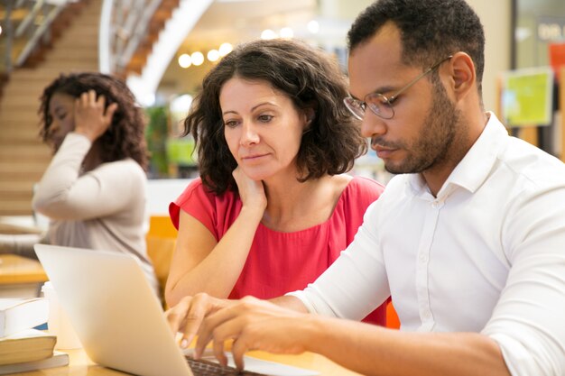 Konzentrierte Menschen lesen Informationen vom Laptop