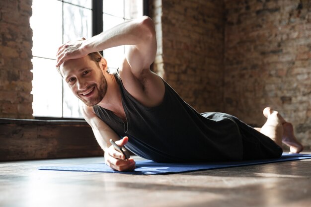 Konzentrierte starke Sportler im Fitnessstudio machen Yoga-Sportübungen.