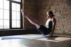 Kostenloses Foto konzentrierte starke sportler im fitnessstudio machen yoga-sportübungen.