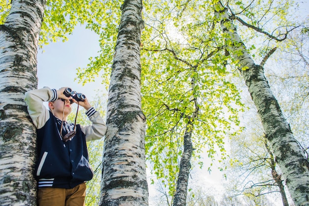 Konzentrierter Junge mit Fernglas im Park