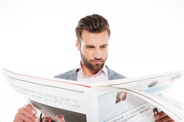 Kostenloses Foto konzentrierter junger mann, der gazette liest