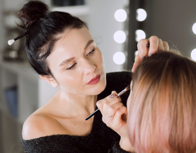Konzentrierter Künstler, der Make-up tut