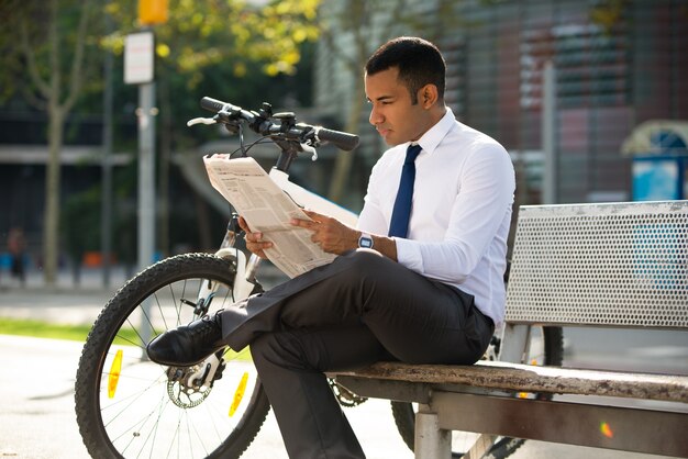 Konzentrierter Manager, der Zeitung im Freien liest