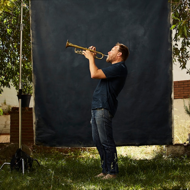 Kostenloses Foto konzentrierter musiker, der sein instrument spielt