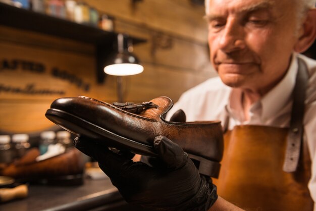 Konzentrierter Schuhmacher in der Werkstatt, der Schuhe herstellt