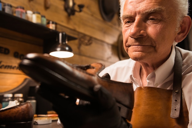 Konzentrierter Schuhmacher in der Werkstatt, der Schuhe herstellt