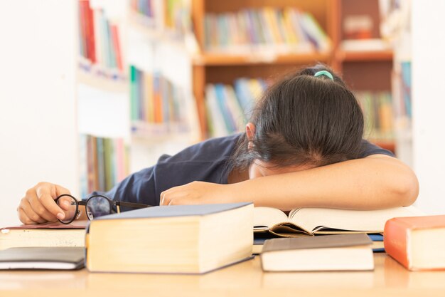 Konzentriertes Schülerlesebuch an ihrem Schreibtisch in einer Bibliothek