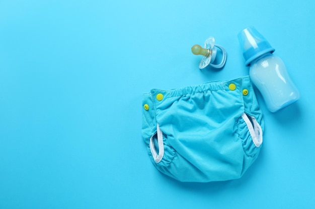 Konzept der babykleidung mit wiederverwendbaren windeln auf blauem hintergrund
