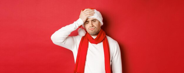 Konzept der Weihnachtswinterferien und Feierporträt eines traurigen und frustrierten Mannes mit Weihnachtsmütze...