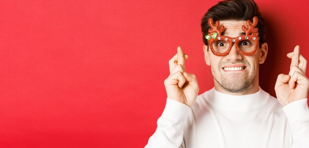 Konzept der Winterferien Weihnachten und Feiern Nahaufnahme eines nervösen Mannes mit Partybrille überqueren ...