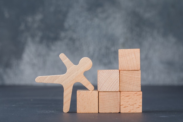 Konzept des Geschäfts mit Holzklötzen wie Treppen mit hölzerner menschlicher Figur.