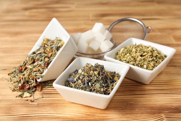 Konzept des kochens von tee mit verschiedenen teesorten auf holzhintergrund