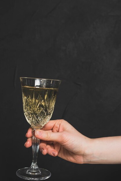 Konzept des neuen Jahres mit der Hand, die Champagnerglas hält