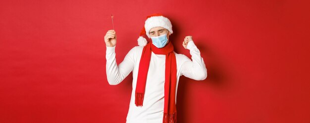 Konzept von Covid-Weihnachten und Feiertagen während der Pandemie Glücklicher Mann, der das neue Jahr bei Partykleidung feiert
