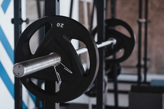 Konzeption von Stärke. Schwarze Langhantel auf dem Metallständer im Fitnessstudio tagsüber. Keine Leute da