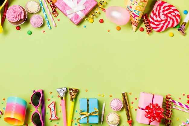 Kopieren Sie Platz mit Geburtstagseinzelteilen und Süßigkeiten auf grünem Hintergrund